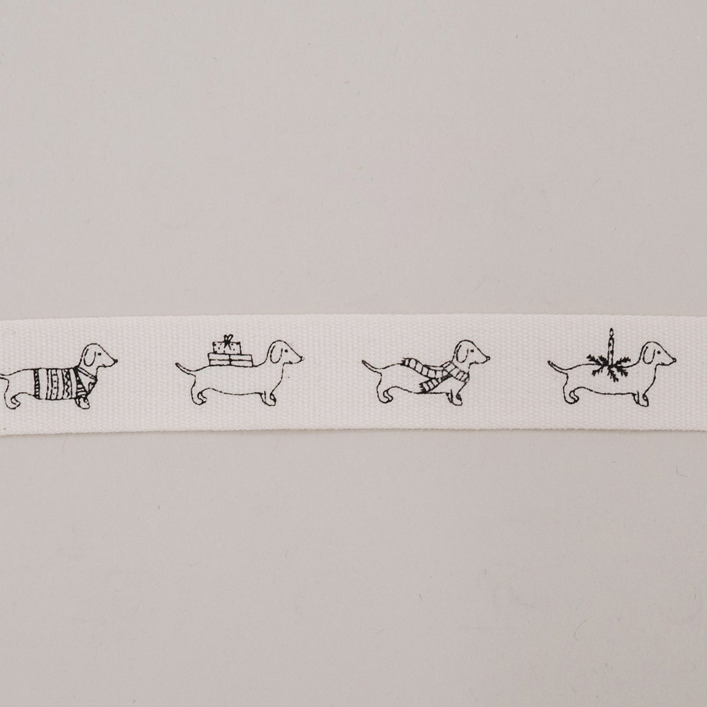 Geschenkband mit Weihnachtsdackeln aus Baumwolle, vier Dackel-Motive auf Band nebeneinander