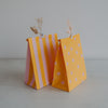 Gelbe Geschenktüten mit rosa Streifen und Punkten, aus Papier, liebevoll dekoriert mit Trockenblumen