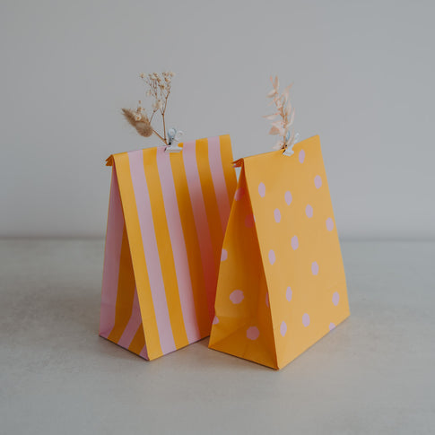 Gelbe Geschenktüten mit rosa Streifen und Punkten, aus Papier, liebevoll dekoriert mit Trockenblumen