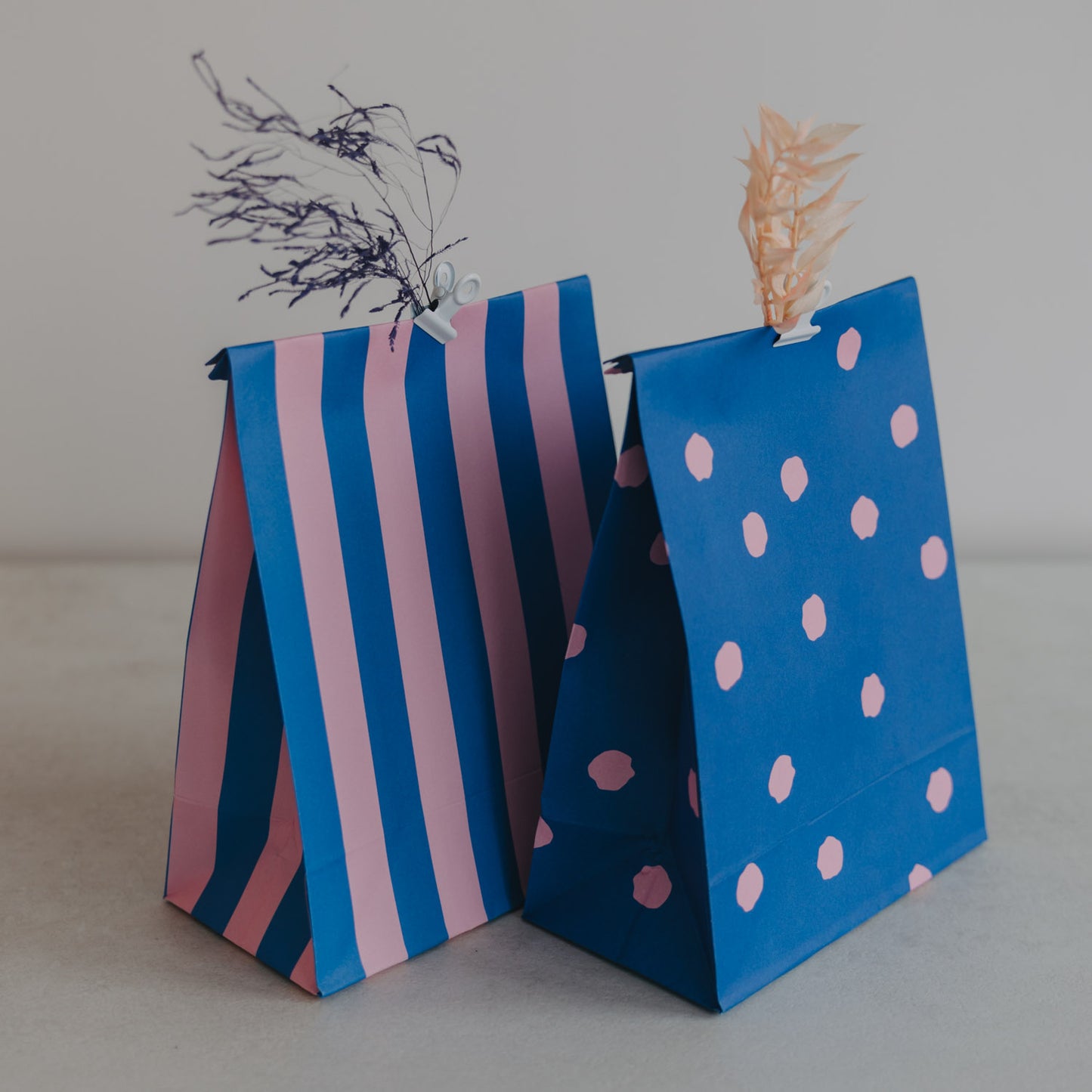 Blaue Geschenktüten mit rosa Streifen und Punkten, moderne Papier-Geschenktüten mit dekorativen Details