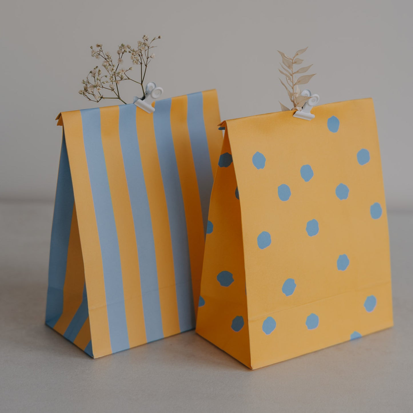 Zwei gelbe Papiertüten mit blauen Punkten und Streifen, Teil des 6er Geschenkbeutel-Sets