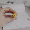 Radiergummi Smiley wird in der Hand gehalten vor Notizblock