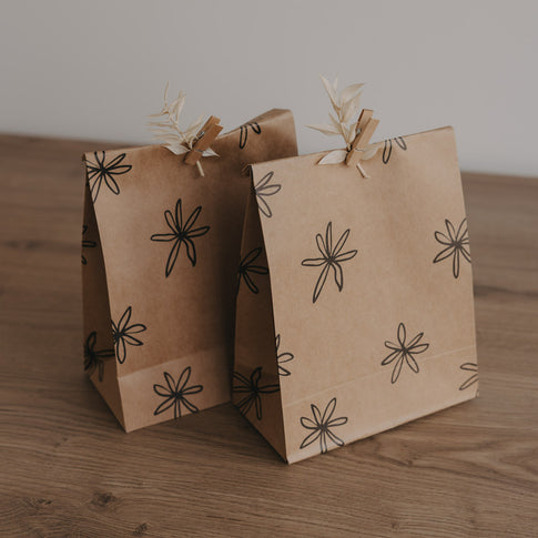 Geschenkbeutel aus Kraftpapier mit grafischem Blumenmuster in Schwarz, minimalistisch und natürlich